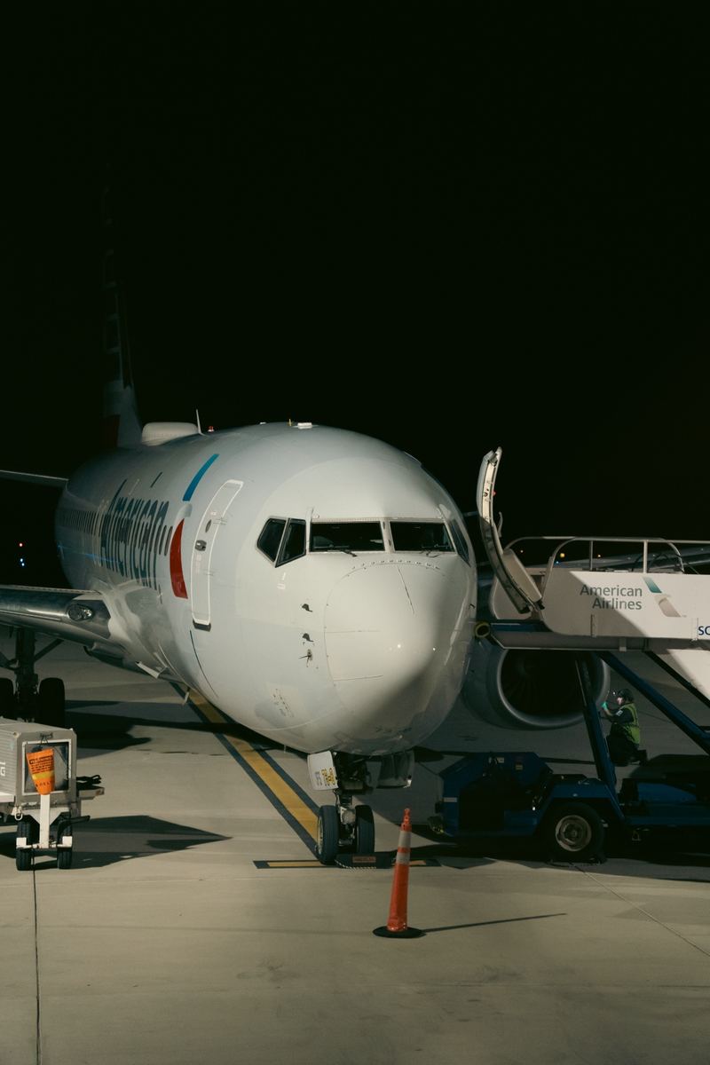 American Airlines jet parked at the gate at RDU airport at night