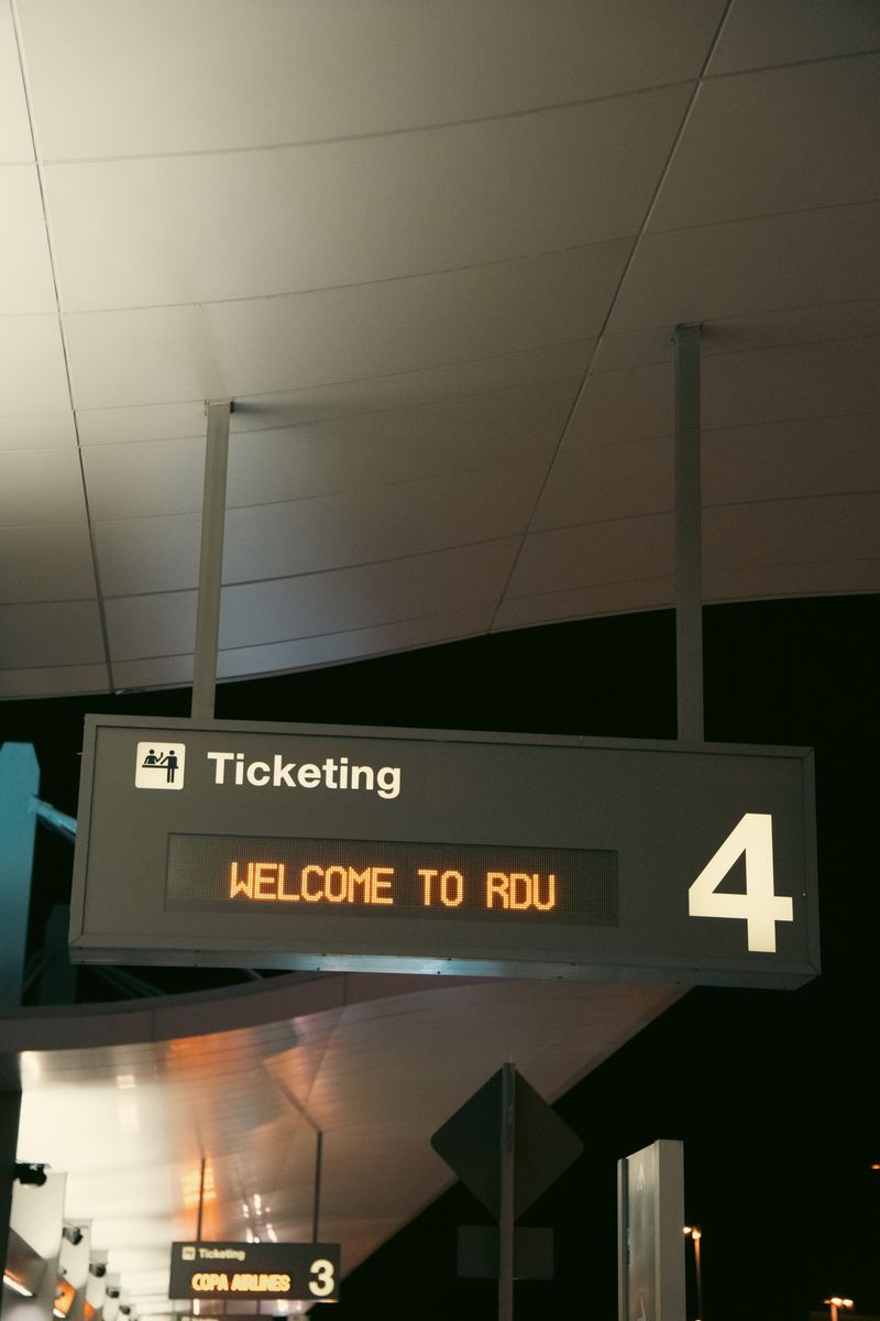 'Welcome to RDU' sign above the ticketing area at Raleigh-Durham International Airport at night