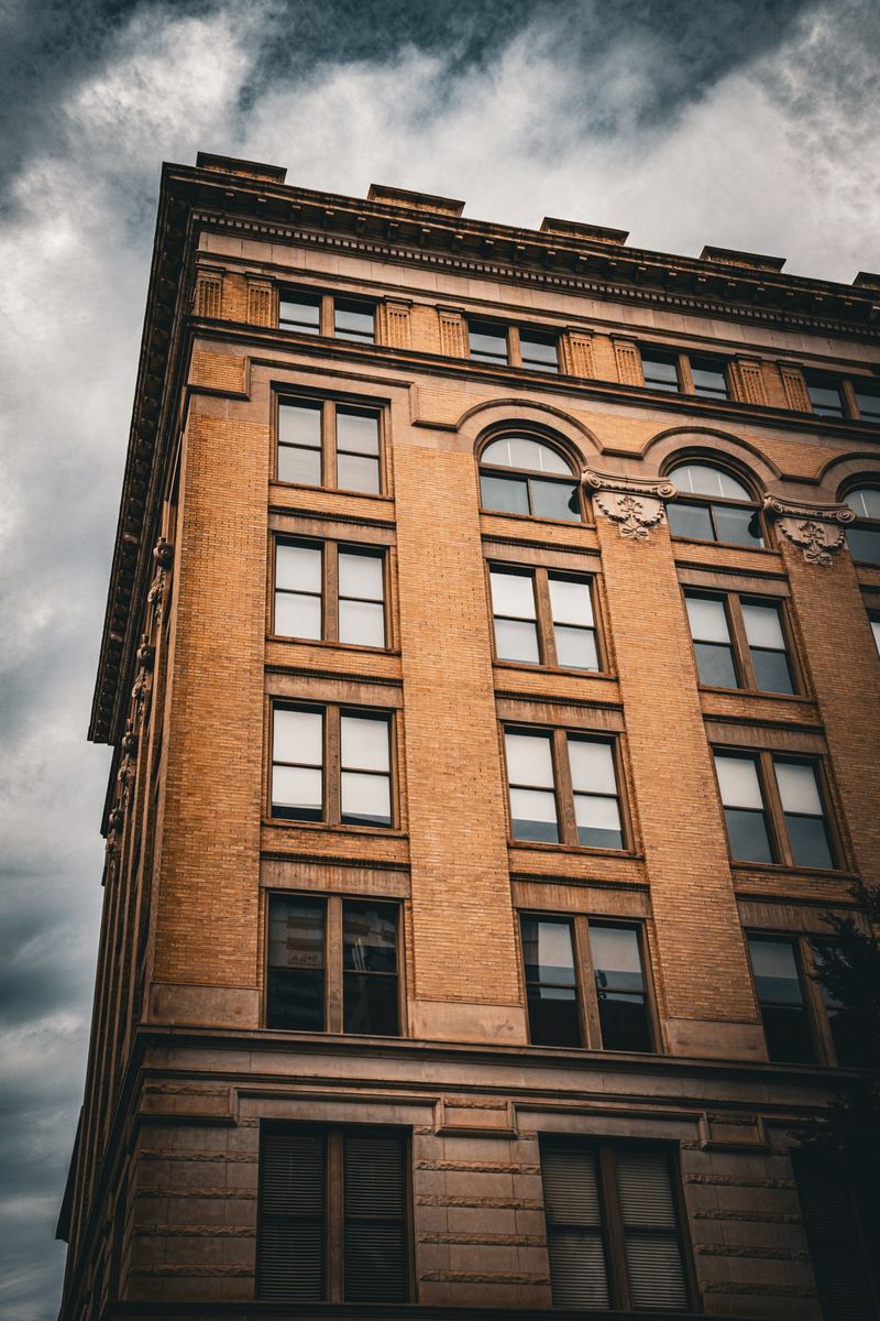 Historic brick building facade in downtown Raleigh against a cloudy sky