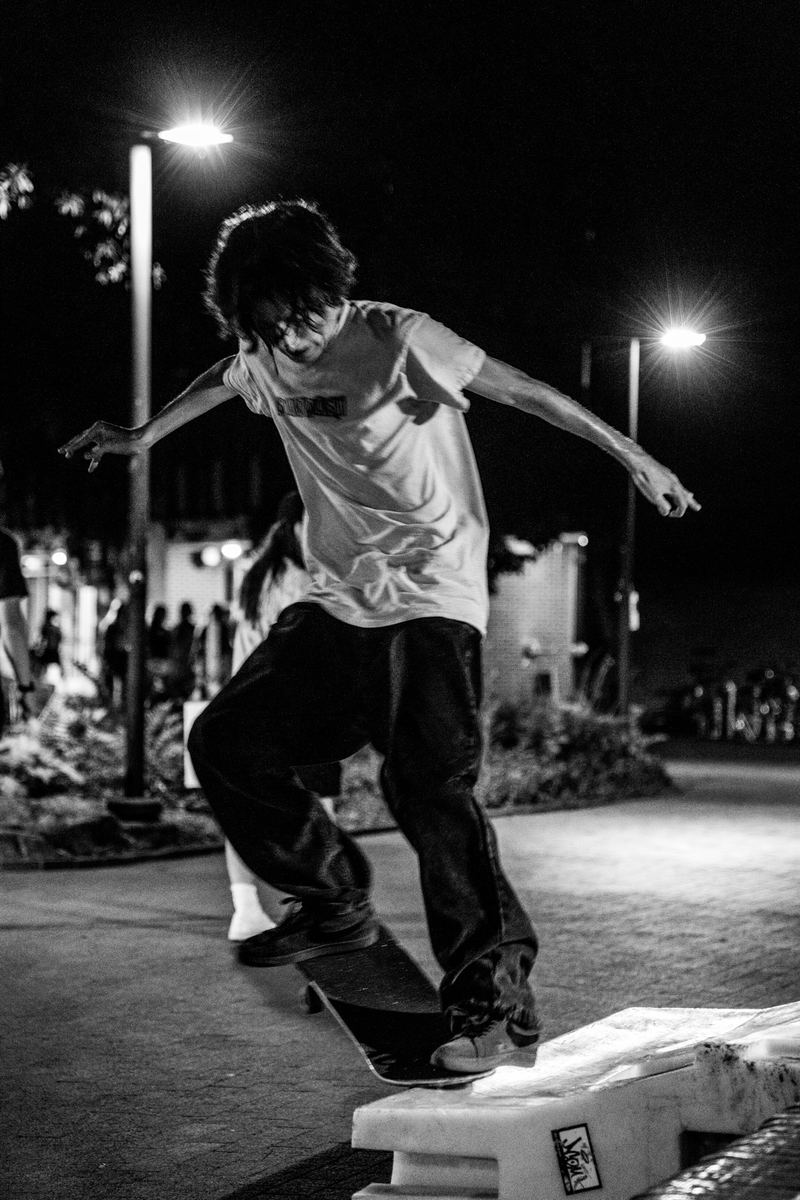 Black-and-white photo of a skateboarder mid-air at night in Raleigh