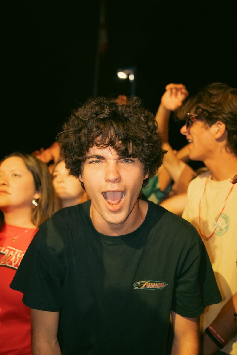 Excited young man cheering in a nighttime concert crowd in Raleigh