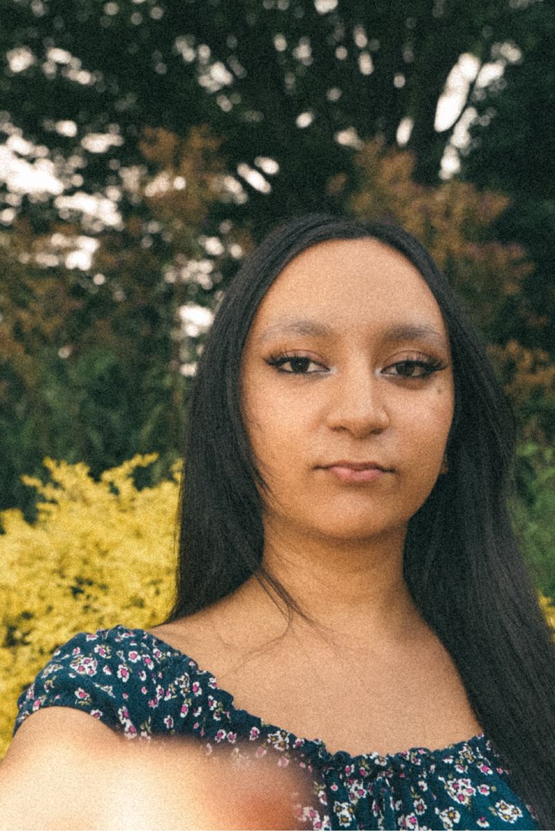 Natural-light portrait of a young woman in a floral top outdoors in Raleigh